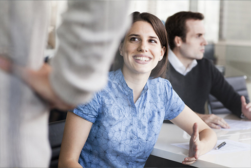 Woman engaged in conversation with a man at a desk