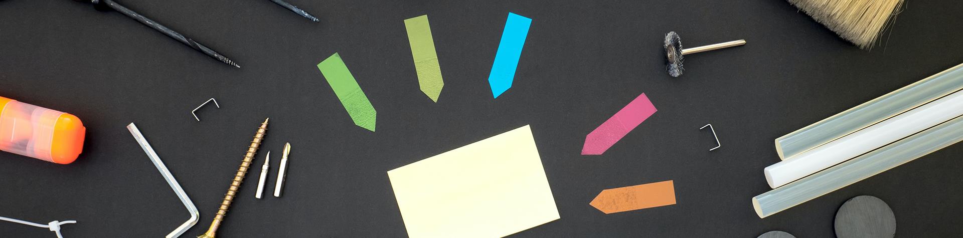 Tools and stationary laid out on a black table