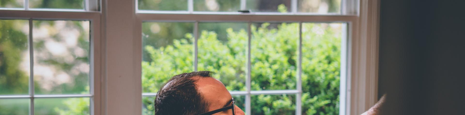 document being handed over to someone sitting in front of a computer