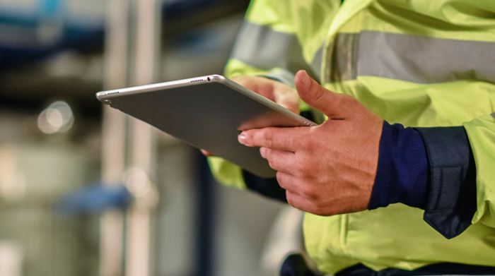 Man completing E-Learning on tablet in high-viz
